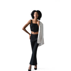 Woman wearing a black outfit with a white blazer on a white background