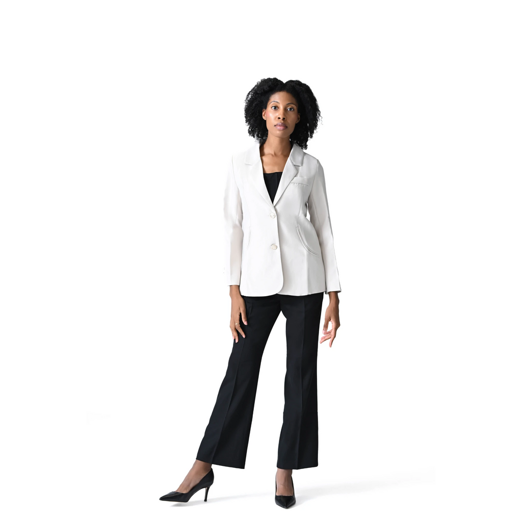 Woman wearing a white blazer and black pants on a white background